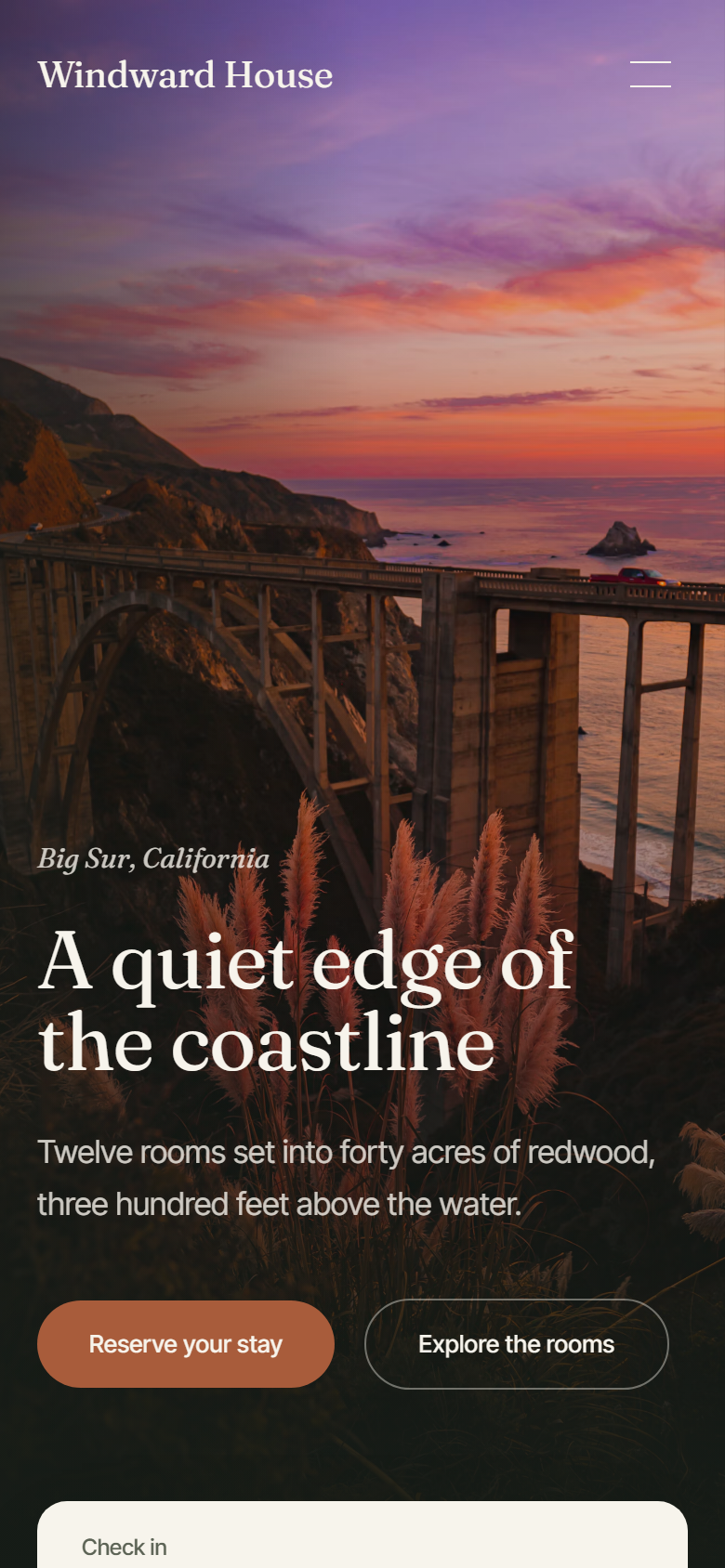 Windward House home page on a phone: the sunset coastline photo, the headline and two booking buttons.